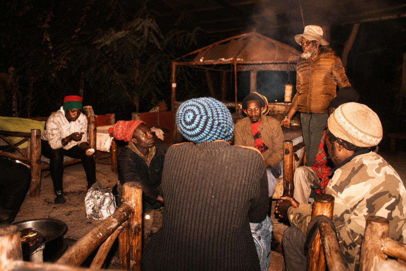 Community gathering around a fire recording oral histories at night